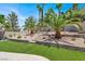 Landscaped backyard featuring tiered garden beds, palm trees, and green grass, creating a serene oasis at 2102 Rhonda Ter, Henderson, NV 89074