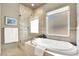 Luxurious bathroom features a separate glass shower, large soaking tub, and natural light from a window at 2102 Rhonda Ter, Henderson, NV 89074
