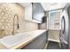 Efficient laundry room with modern appliances, overhead cabinets, and stylish backsplash at 2102 Rhonda Ter, Henderson, NV 89074