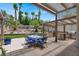 Beautiful backyard patio featuring a dining table, outdoor kitchen, and a lush landscape with palm trees at 2102 Rhonda Ter, Henderson, NV 89074