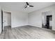 Open bedroom with wood-look floors, ceiling fan, access to walk-in closet, and adjacent luxury bathroom at 2110 S Manzanita Dr, Pahrump, NV 89048