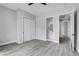 Bedroom with gray walls features wood-look flooring, closet, ceiling fan, and bathroom access at 2110 S Manzanita Dr, Pahrump, NV 89048