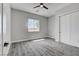 Neutral bedroom features wood-look flooring, large window, ceiling fan, and large closet at 2110 S Manzanita Dr, Pahrump, NV 89048