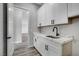 Convenient laundry room boasts white cabinets, marble counters, and a modern black faucet at 2110 S Manzanita Dr, Pahrump, NV 89048