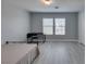 Bedroom featuring light gray walls, flooring and a bed frame with a desk pushed up against a window at 212 Stagecoach Flats, Las Vegas, NV 89031