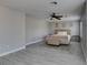 Spacious main bedroom featuring light gray walls, wood look floors, ceiling fan and several sunny windows at 212 Stagecoach Flats, Las Vegas, NV 89031