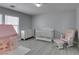 This Bedroom features gray walls, wood look floors, and a white crib, dresser, rocking chair and play tent at 212 Stagecoach Flats, Las Vegas, NV 89031