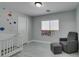 Bright bedroom featuring a crib, chair and ottoman, and a window that provides natural light at 212 Stagecoach Flats, Las Vegas, NV 89031