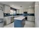 Modern kitchen with stainless steel appliances, large countertops, an island, and blue tile backsplash at 212 Stagecoach Flats, Las Vegas, NV 89031