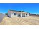 Rear exterior featuring a covered patio and a spacious, leveled, dirt-covered backyard at 2150 S Manzanita Dr, Pahrump, NV 89048