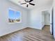 Cozy bedroom featuring wood-style flooring, a ceiling fan, and large window view at 2150 S Manzanita Dr, Pahrump, NV 89048