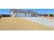 A single-story home featuring desert landscaping, a large driveway, and a modern architectural design at 2150 S Manzanita Dr, Pahrump, NV 89048