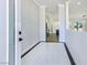 Bright foyer featuring glossy tiled floors, white walls, and an open view into the modern kitchen at 2150 S Manzanita Dr, Pahrump, NV 89048