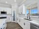 Close-up of the kitchen sink with white cabinets, quartz countertops, and window view at 2150 S Manzanita Dr, Pahrump, NV 89048