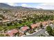Community aerial shot showcasing single-story homes with tile roofs, green spaces and mountain backdrop at 2509 Big Timber Dr, Las Vegas, NV 89134