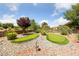 Backyard putting greens surrounded by rock ground cover, bushes and a small tree at 2509 Big Timber Dr, Las Vegas, NV 89134
