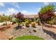 Single-story home with desert landscaping including decorative rock and manicured shrubs and trees at 2509 Big Timber Dr, Las Vegas, NV 89134