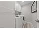 This laundry room has front loading washer and dryer with sleek white cabinets for storage and a gray wall at 2509 Big Timber Dr, Las Vegas, NV 89134