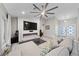 Bright living room with a large ceiling fan, modern fireplace, and comfortable neutral-toned sofa at 2509 Big Timber Dr, Las Vegas, NV 89134