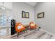Cozy sitting area with comfortable orange chairs, modern artwork, and elegant hardwood flooring at 2509 Big Timber Dr, Las Vegas, NV 89134