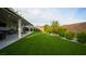 Backyard with lush artificial turf, landscape, covered patio, and privacy wall for serene outdoor living at 2913 Monate Ct, Henderson, NV 89044