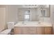 Well-lit bathroom with double sink vanity, toilet and large mirror at 3060 Tarpon Dr # 102, Las Vegas, NV 89120