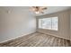 Neutral bedroom with ceiling fan, laminate flooring, and natural light from large window at 3060 Tarpon Dr # 102, Las Vegas, NV 89120