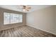 Bright bedroom with wood-look floors, a ceiling fan, and a large, bright window at 3060 Tarpon Dr # 102, Las Vegas, NV 89120