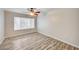 Comfortable bedroom featuring wood-look floors, ceiling fan, and a bright window at 3060 Tarpon Dr # 102, Las Vegas, NV 89120