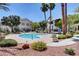 Community pool area with palm trees, lush landscaping, and attractive residential buildings on a clear, sunny day at 3060 Tarpon Dr # 102, Las Vegas, NV 89120