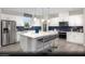 Modern kitchen features stainless steel appliances, a large island with seating, and stylish blue backsplash at 314 S Parawan St # Lot 13, Henderson, NV 89015