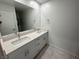 Bathroom featuring double sinks, white cabinets, and a large mirror at 3194 Lumassina Way, Henderson, NV 89044