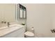 Cozy powder room featuring a modern vanity, sink, toilet, and gray cabinet at 3194 Lumassina Way, Henderson, NV 89044