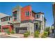 Modern two-story home with a gray stucco exterior and red siding accent, complemented by a well-maintained front yard at 3194 Lumassina Way, Henderson, NV 89044