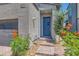 Inviting entryway featuring a blue front door, landscaped garden, and a paved walkway leading to the entrance at 3194 Lumassina Way, Henderson, NV 89044