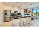 Well-lit kitchen with stainless steel appliances, island seating, and a view to the dining area at 3194 Lumassina Way, Henderson, NV 89044