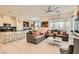 Open-concept living room featuring modern furnishings, a ceiling fan, and access to a well-equipped kitchen at 3194 Lumassina Way, Henderson, NV 89044