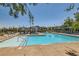 Community pool with lounge chairs, umbrellas, and a shallow wading area with handicap-accessible railings at 3194 Lumassina Way, Henderson, NV 89044