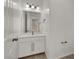 Well-lit half-bathroom with white vanity, contemporary mirror, and neutral color palette at 348 Andy Wheeler Dr, Henderson, NV 89011