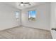 Bright bedroom with neutral carpet, white walls, a ceiling fan, and two windows overlooking the exterior at 348 Andy Wheeler Dr, Henderson, NV 89011