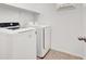 Laundry room with modern, matching, white washer and dryer, white shelving, and tile flooring at 348 Andy Wheeler Dr, Henderson, NV 89011