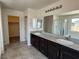 Bathroom featuring double sink vanity with granite counters, framed mirror and tiled floors at 4104 Free Bird Crest Ave, North Las Vegas, NV 89081