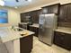 Modern kitchen with stainless steel appliances, granite countertops and dark wood cabinets at 4104 Free Bird Crest Ave, North Las Vegas, NV 89081