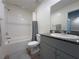 Bathroom featuring granite countertops, gray cabinetry, and a shower-tub combination at 4273 Venus Falls Ave, North Las Vegas, NV 89084