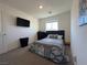 Bedroom features a cozy bed, wall-mounted TV, and a bright window with natural light at 4273 Venus Falls Ave, North Las Vegas, NV 89084