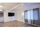Bright living room featuring hardwood floors, large windows, and a sleek mounted TV at 4831 Vermont Ave, Las Vegas, NV 89107