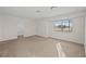 Empty bedroom with large window letting in natural light and a bathroom access at 5458 Walton Heath Ave, Las Vegas, NV 89142