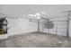 Spacious two-car garage with concrete floors, a water heater, and a white door at 5458 Walton Heath Ave, Las Vegas, NV 89142