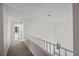 Upstairs hallway with carpet and railings and a view into the bathroom with double sinks at 5458 Walton Heath Ave, Las Vegas, NV 89142