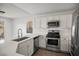 Well-equipped kitchen with stainless steel appliances, quartz countertops, and ample cabinet space at 5458 Walton Heath Ave, Las Vegas, NV 89142